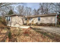 Charming single-story home with light beige siding and a welcoming front entrance with small wood stairs at 58 Knox Rd, Powder Springs, GA 30127