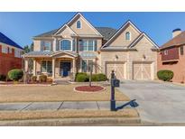 Beautiful two-story brick home with a manicured front yard and a two-car garage in a suburban neighborhood at 5732 Ashleigh Walk Dr, Suwanee, GA 30024