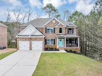 Charming brick two-story home featuring an attached two-car garage and a bright blue front door at 2784 Hilson Commons, Decatur, GA 30034