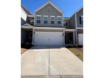 Charming townhome featuring a two-car garage, neutral siding, and well-manicured front yard at 501 Crescent Woode Dr, Dallas, GA 30157