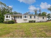 Charming brick home featuring a well-manicured front yard, complemented by bay windows and a welcoming entrance at 156 Page Pl, Canton, GA 30114