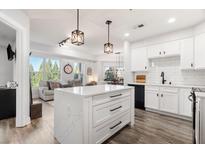 Bright kitchen featuring white cabinets, subway tile backsplash, and a center island with marble countertop at 200 River Vista Dr # 502, Atlanta, GA 30339