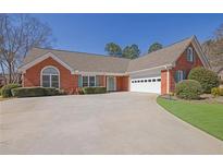 Charming brick home features an attached two-car garage and a well-manicured front yard at 223 Ivy Creek Dr, Loganville, GA 30052