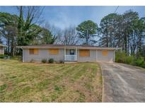 Charming single-story home with a well-maintained lawn and a long private driveway at 4094 E Glade Ct, Decatur, GA 30035