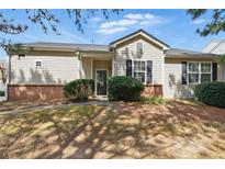 Charming one story home with beige siding, black shutters, brick foundation, and manicured landscaping at 129 Swanee Ln, Woodstock, GA 30188