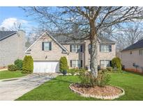 Two-story brick home with black shutters, a well-manicured lawn, and mature landscaping at 165 Babbling Brook, Mcdonough, GA 30252
