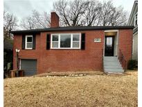 Charming red brick home with a chimney, black shutters, and an attached garage at 211 Wellington Sw St, Atlanta, GA 30314