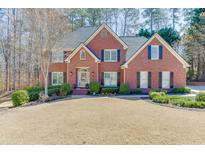 Charming two-story brick home with manicured lawn and landscaping, featuring a classic architectural design and inviting entrance at 4330 Landover Nw Way, Suwanee, GA 30024