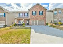 Charming two-story brick home with a well-manicured front yard and a two-car garage at 2461 Melton Common Dr, Dacula, GA 30019