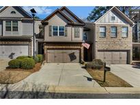 Charming townhome with a two-car garage, stone accents, and manicured landscaping at 2474 Whiteoak Se Run # 18, Smyrna, GA 30080