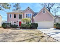 Charming two-story home showcasing a manicured lawn, mature trees, and a driveway leading to a two-car garage at 11605 Dunhill Place Dr, Alpharetta, GA 30005