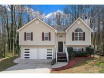 Inviting two-story home with a well-maintained lawn and attached two-car garage at 445 Settlers Ridge Ln, Hiram, GA 30141