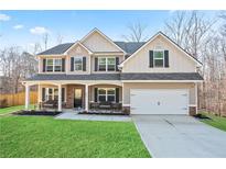 Inviting two-story home with a covered front porch, green lawn, and a two-car attached garage at 441 Ajo Way, Dallas, GA 30157