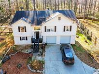 Inviting home featuring a two-car garage, landscaped front yard, and a charming entryway with stairs at 45 Side Trail, Covington, GA 30016
