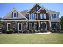 Stunning two-story home featuring stone and brick accents, complemented by lush landscaping and a well-manicured lawn at 838 Natchez Valley Trce, Grayson, GA 30017