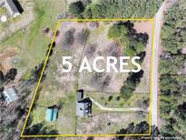 This aerial view showcases a sprawling 5-acre property, featuring a home, outbuildings, and lush greenery at 3121 Cox Cemetery Rd, Social Circle, GA 30025