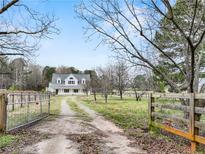 Charming two-story farmhouse with a long private driveway and gated entry at 3121 Cox Cemetery Rd, Social Circle, GA 30025