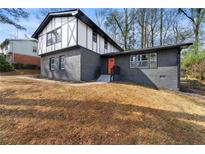 Two-story home featuring a freshly painted brick facade and a contrasting white upper level with black trim details at 1025 S Indian Creek Dr, Stone Mountain, GA 30083