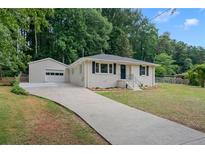 Charming single story home featuring a separate garage and long concrete driveway at 851 Daniell Se Dr, Smyrna, GA 30080