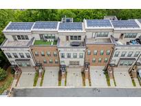 Modern townhomes featuring rooftop terraces, solar panels, and attached garages for sustainable living at 1049 Brandsford Nw St # 27-01, Atlanta, GA 30318