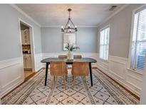 Bright dining room with modern chandelier, stylish rug, and comfortable seating for memorable meals at 1510 Ridgemill Ter, Dacula, GA 30019