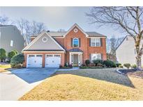 Charming two-story brick home with a well-manicured lawn and a two-car garage at 1510 Ridgemill Ter, Dacula, GA 30019