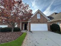 Charming brick home with a two-car garage, well-kept landscaping, and a welcoming entrance at 1890 Glenhurst Dr, Snellville, GA 30078