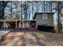 View of a two-story home with brick and wood facade, covered parking, and a yard at 2836 Oldknow Dr, Atlanta, GA 30318