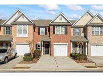 Traditional red brick townhome featuring a single-car garage and a well-maintained front yard with manicured shrubbery at 3815 Pleasant Oaks Dr, Lawrenceville, GA 30044