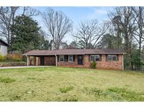 Charming brick home with a covered carport and a well-maintained front lawn at 422 Derbyshire Dr, Stone Mountain, GA 30088