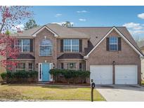 Charming two-story brick home with a well-manicured lawn, blue door, and attached two-car garage at 1771 Deer Crossing Cir, Jonesboro, GA 30236
