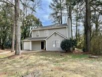 Charming two-story home with neutral siding, attached garage and mature trees at 5463 Forest East Ln, Stone Mountain, GA 30088
