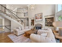Spacious living room with a fireplace, a large staircase, hardwood floors, and a beautiful chandelier at 5120 Parkwood Oaks Ln, Smyrna, GA 30126