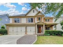 Beautiful two-story home with a brick and siding exterior, three-car garage, and well-manicured front lawn at 3305 Suffolk Dr, Cumming, GA 30041