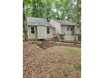 Charming home featuring a neutral palette, newer windows, and lush landscaping with a stone foundation at 6739 Valley Ct, Douglasville, GA 30135