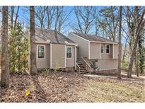 Charming exterior view of this cozy home with neutral siding and natural surroundings on a sunny day at 6739 Valley Ct, Douglasville, GA 30135
