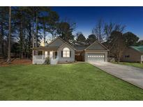 Charming single-story home featuring a covered porch, attached garage, and well-maintained lawn at 140 Double D Rd, Temple, GA 30179