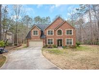 Charming two-story brick home with a well-manicured front yard and two car garage at 1705 Butler Bridge Rd, Covington, GA 30016