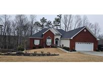 Charming brick home with a well-manicured lawn and attached two car garage at 70 Trelawney Cir, Covington, GA 30016