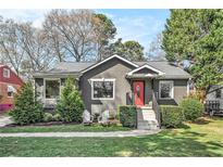 Charming stucco home featuring a red front door, manicured landscaping, and a walkway leading to the entrance at 1552 Newton Se Ave, Atlanta, GA 30316