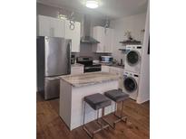 Charming kitchen featuring stainless steel appliances, an island with seating, and a stacked washer/dryer at 3060 Pharr Court North Nw # 306, Atlanta, GA 30305