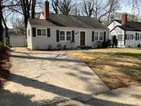Charming single-Gathering home featuring a concrete driveway, well-kept lawn, and a detached garage at 1132 Fair St, Atlanta, GA 30314