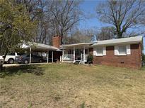 Charming single-story brick home featuring a covered front porch and a convenient carport at 459 N Norcross Tucker Rd, Norcross, GA 30071
