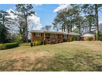 Charming brick home with a covered front porch and large front yard at 1703 Alton Way, Marietta, GA 30062