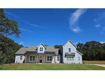 Charming light blue home with a well-manicured lawn and inviting front porch at 1715 Crumbley Rd, Mcdonough, GA 30252