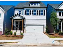 Charming two-story home featuring a white facade, black shutters, and a two-car garage at 1225 Westshore Dr, Cumming, GA 30041