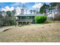 Charming two-story home featuring a cozy front porch, mature trees, and inviting curb appeal at 419 Saint Patrick Sw Dr, Mableton, GA 30126