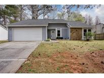 Charming home with a two-car garage, stone accents, and a well-maintained front lawn at 4938 Terrace Green Trce, Stone Mountain, GA 30088