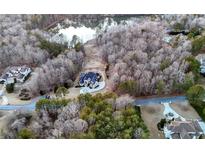 Stunning aerial view of a luxury home on a large wooded lot with lake frontage at 4233 Sandstone Shores Dr, Stonecrest, GA 30038