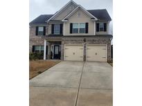 Charming two-story home featuring a brick and siding facade, a two-car garage, and a well-maintained lawn at 2436 Planters Mill Way, Conyers, GA 30012